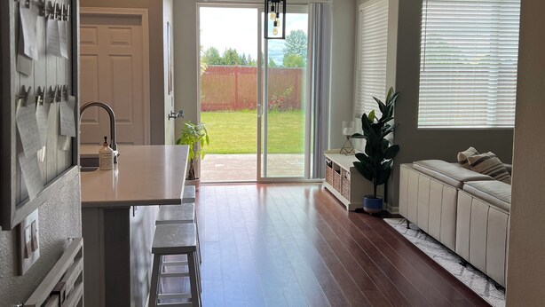 A spacious kitchen with a central island, a dining area with a bench, and a sliding glass door leading to a backyard. - 4 Bedroom with all the things! (Eugene)