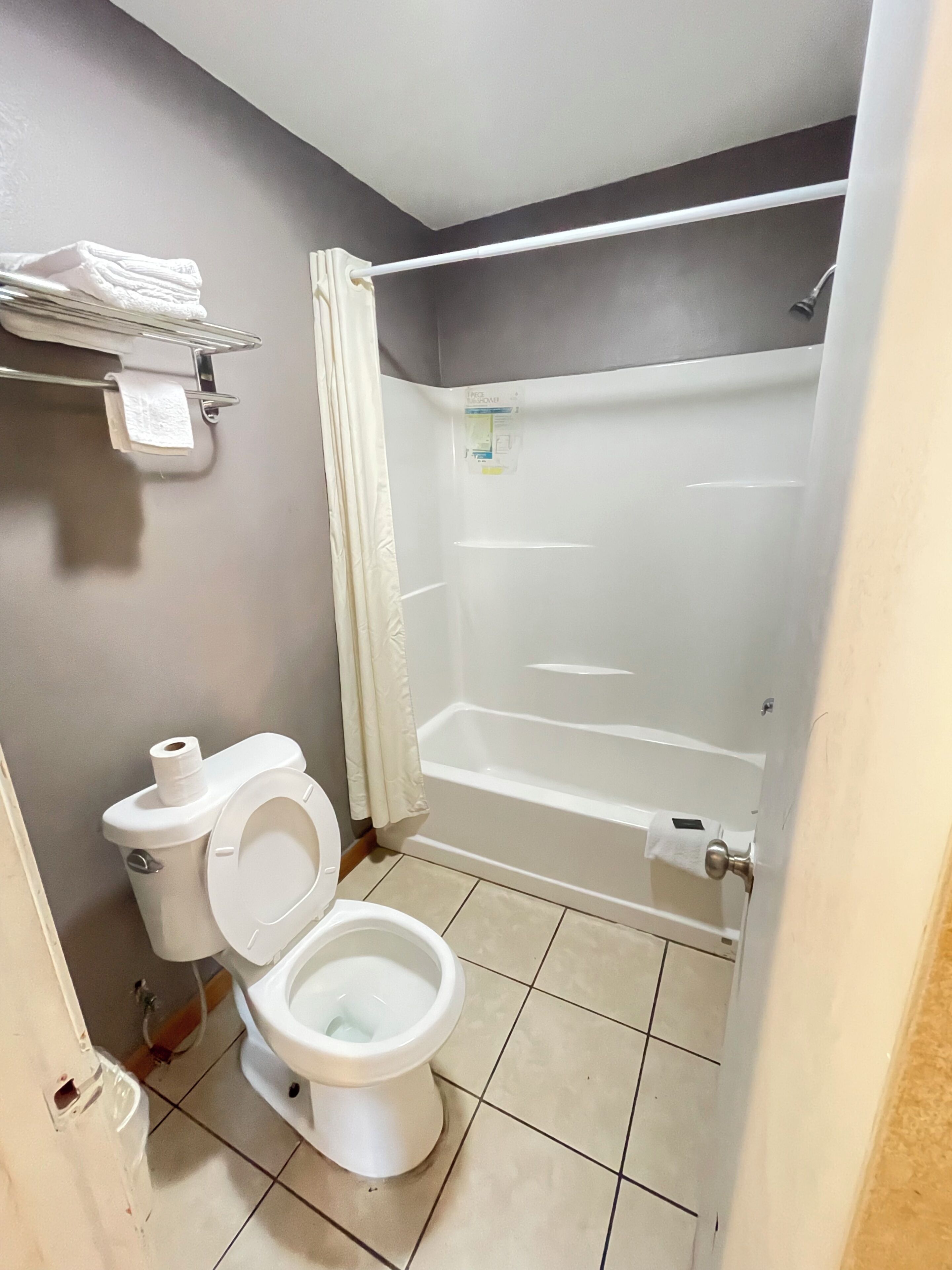 Un baño con inodoro, bañera y cortina de ducha.
