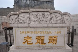 Eine Steintafel mit eingekerbten Figuren und chinesischen Schriftzeichen.
