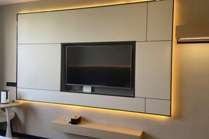 A wall-mounted flat-screen TV in a modern hotel room. - Wuyuan Jindan City Homestay (Wuyuan)