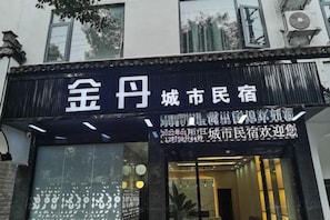 Un hotel con fachada negra y un letrero con caracteres chinos.