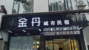 Entrada de un hotel con un letrero que muestra el nombre y un mensaje de bienvenida.