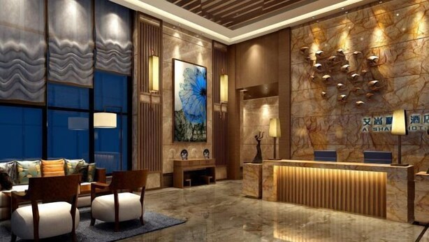 Een hotel receptie met een marmeren balie, een groot abstract schilderij en een zithoek met banken en stoelen.