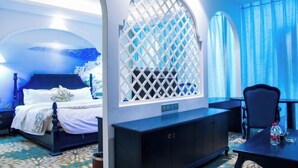 Een hotelkamer met een bed, een bureau, een stoel, een kast en een raam met gordijnen.