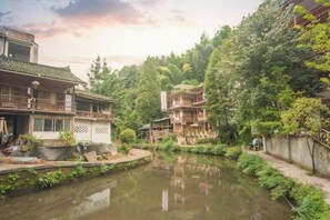 A traditional building with a balcony, a pond, and dense greenery. - Shangli Ancient Town juxianzhuang farmhouse (Ya'an)