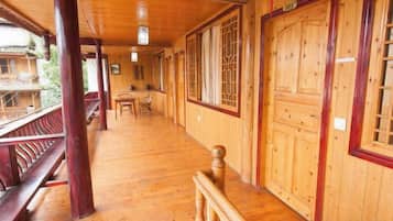 A wooden corridor with a bench, a table, and a door.