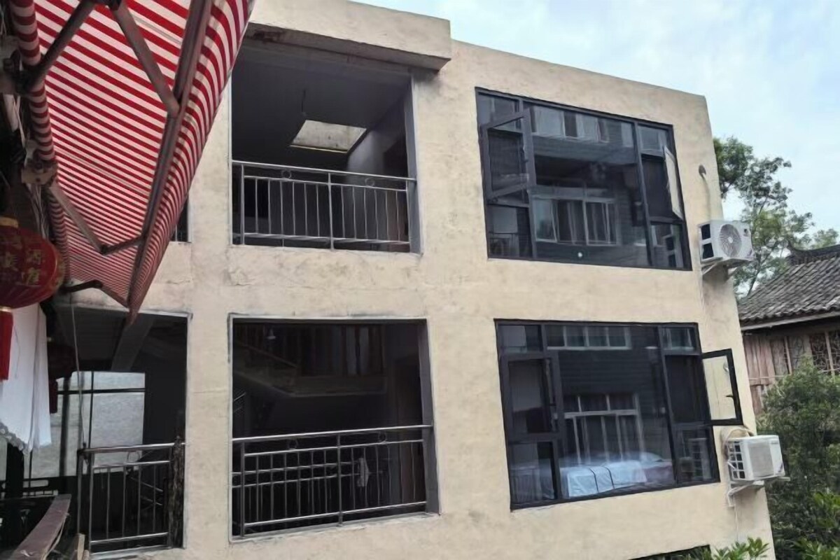 A two-story building with multiple windows, some with metal bars.