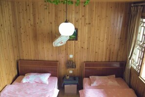 A room with wooden walls and two beds with floral bedding. - Shangli Ancient Town juxianzhuang farmhouse (Ya'an)