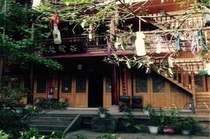 Un edificio tradicional con una escalera de madera, un balcón y plantas en macetas.