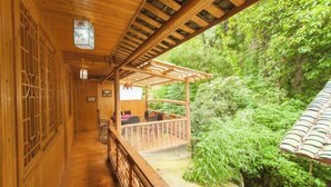 A wooden corridor with a wooden deck and a view of lush greenery. - Shangli Ancient Town juxianzhuang farmhouse (Ya'an)