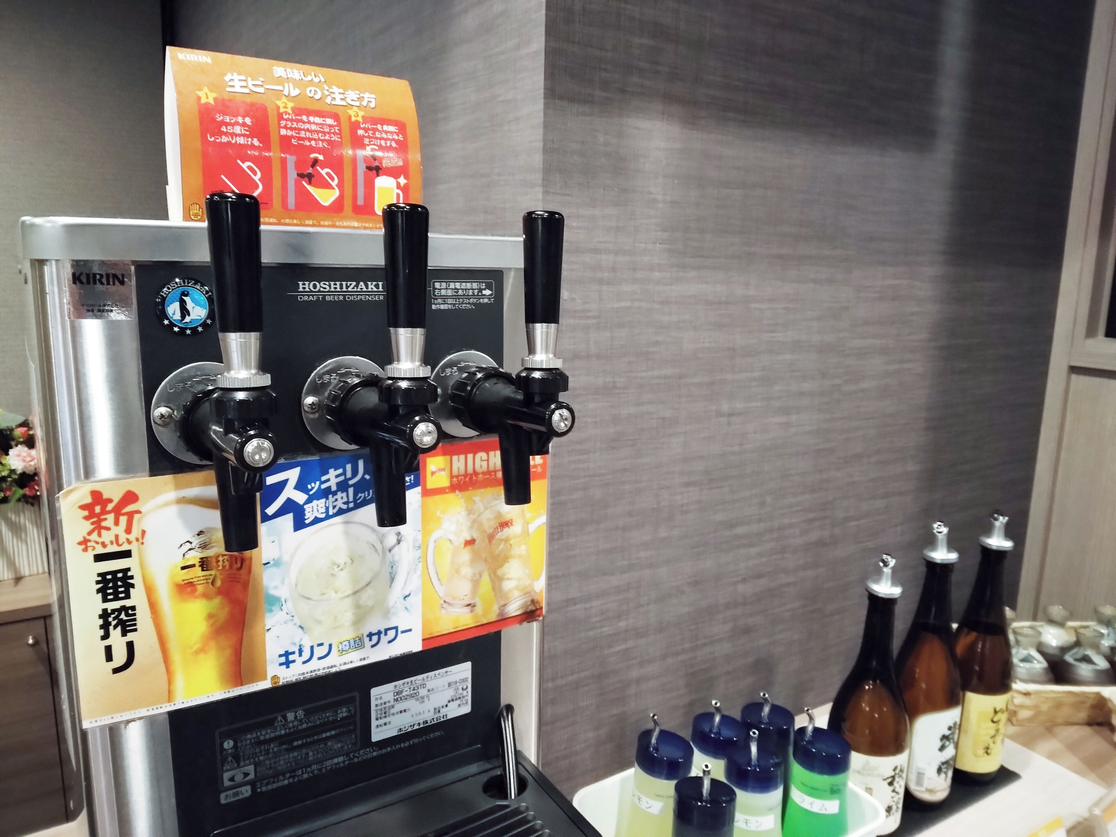 Un dispensador de cerveza con múltiples grifos y un cartel promocional.