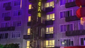 A multi-story building with illuminated signage and windows.