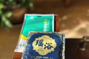 A package labeled "Yao Bath" with a blue and gold design, placed on a wooden surface with a blurred background. - Liaokuo Jingshe Hotel (Qujing)