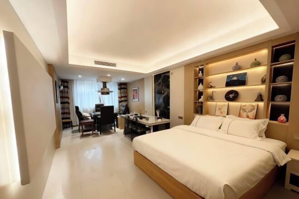 Habitació d'hotel moderna amb un llit gran, un escriptori i zona de seients.