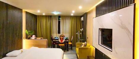 Een moderne hotelkamer met een groot bed, een bureau, een gele fauteuil en een aan de muur bevestigde televisie.