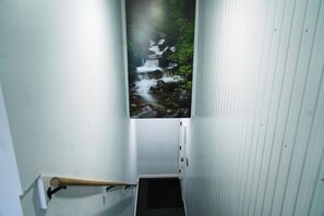 A narrow hallway with a wall-mounted image of a waterfall.