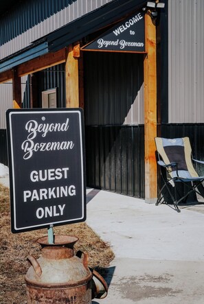 A sign indicating guest parking only in front of a building with a 'Welcome to Beyond Bozeman' sign.