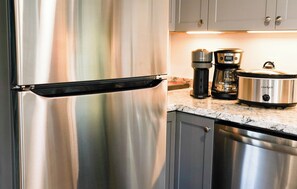 A stainless steel refrigerator with a black handle, a coffee maker, and a slow cooker on a kitchen countertop. - Peaceful Private Loft - 3 Min to Hot Springs (Bozeman)