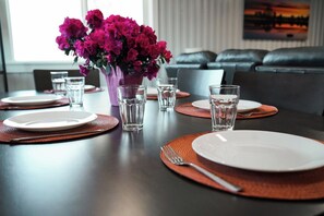 A dining table set with plates, cutlery, and glasses, with a vase of flowers in the center. - Peaceful Private Loft - 3 Min to Hot Springs (Bozeman)
