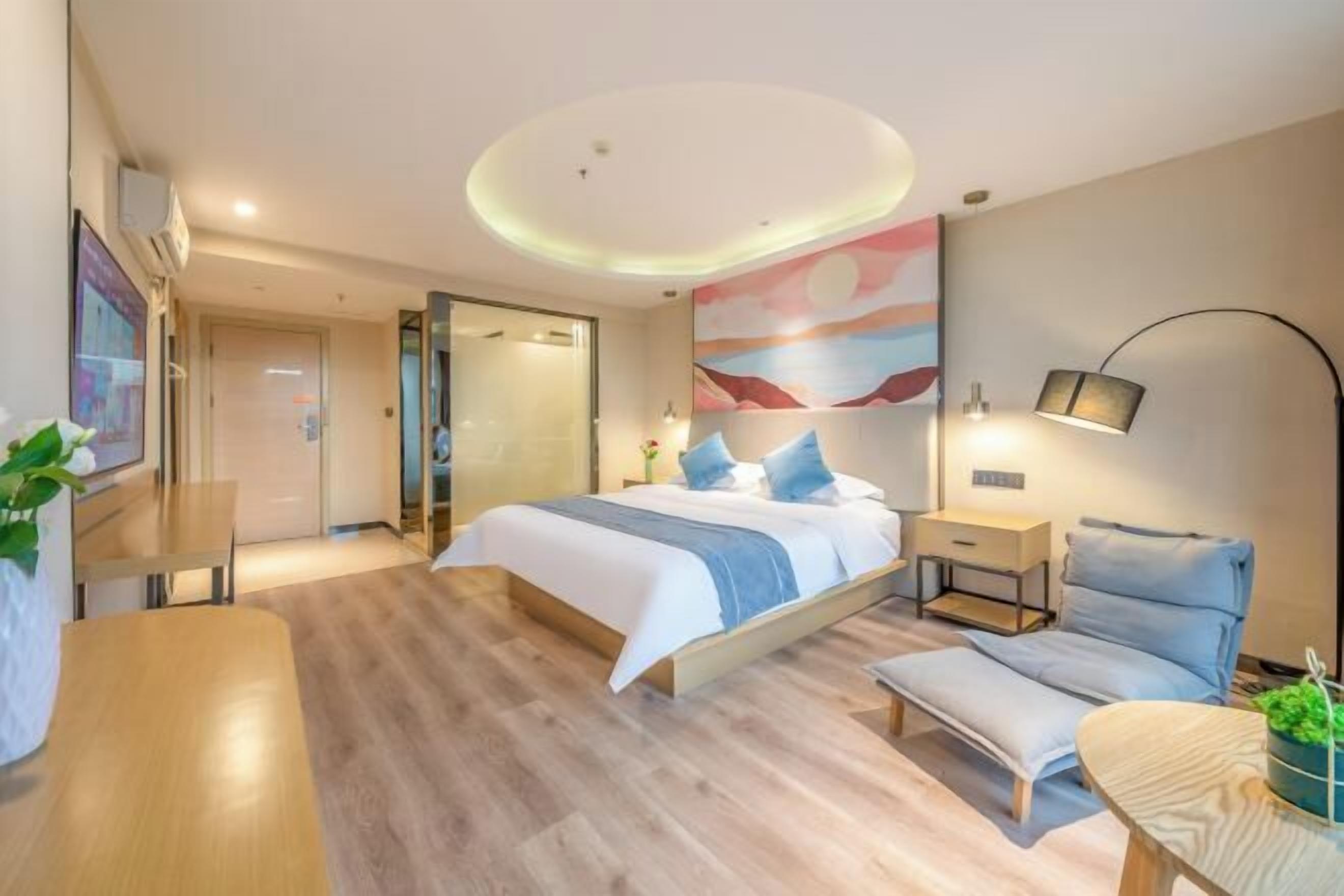A modern bedroom with a bed, bedside tables, a desk, and a chair.
