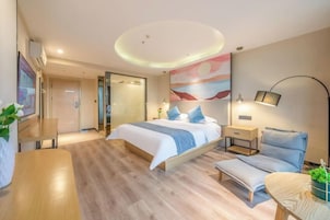 Un dormitorio moderno con cama, mesitas de noche, escritorio y silla.