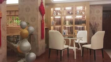 A room with a fireplace, a bookshelf, and two chairs.