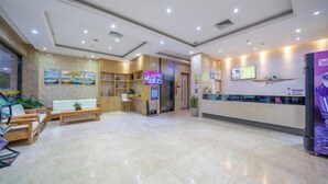 A spacious lobby with a reception desk, seating area, and a TV screen. - Dc cheng hotel (Beiliu)