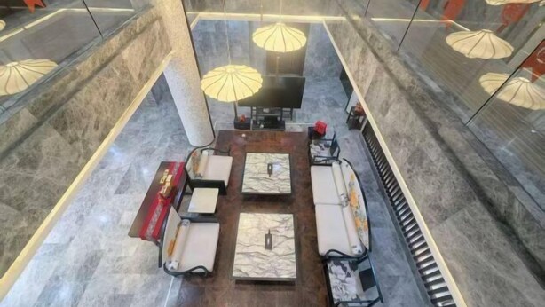 A hotel lobby with a central seating area, glass walls, and hanging lamps. - Mingzhu Lake Swan Garden Resort (Shanghai)