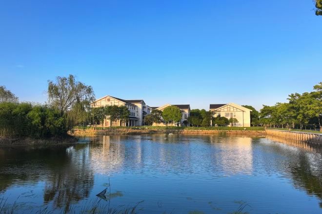 Een woonwijk met huizen in de buurt van een rustig waterlichaam, dat de gebouwen weerspiegelt.
