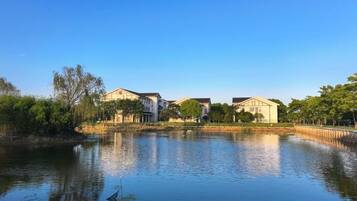 Een woonwijk met huizen in de buurt van een rustig waterlichaam, dat de gebouwen weerspiegelt.