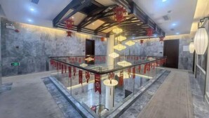 A modern lobby with a glass railing, marble flooring, and decorative lanterns. - Mingzhu Lake Swan Garden Resort (Shanghai)