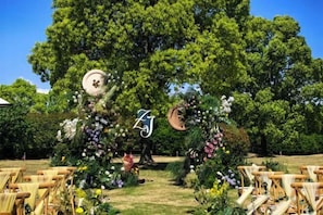 Une cérémonie de mariage en plein air, agrémentée de décorations florales et de chaises en bois disposées pour les invités.