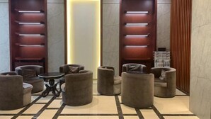 A lobby with seating areas, a central light feature, and wooden paneling. - Mingzhu Lake Swan Garden Resort (Shanghai)