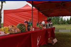 Una carpa roja con una mesa mostrando alimentos y bebidas.