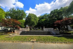 A park with a staircase leading to a building, surrounded by trees and a clear sky. - Mingzhu Lake Swan Garden Resort (Shanghai)