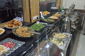 A buffet with various food items and serving utensils. - Guang'anxin Hotel (Barkol)