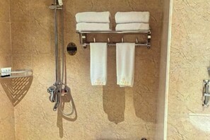 A bathroom with a shower, two towels on a rack, and a towel rack with two towels hanging. - Guang'anxin Hotel (Barkol)