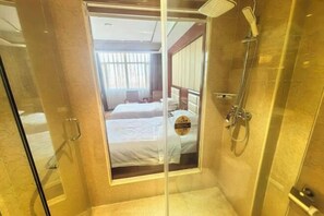 A hotel room with a glass door leading to a shower area, a bed with white linens, and a visible sign with text. - Guang'anxin Hotel (Barkol)