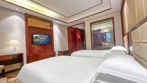 A hotel room with two beds, a TV, and a mirror. - Guang'anxin Hotel (Barkol)