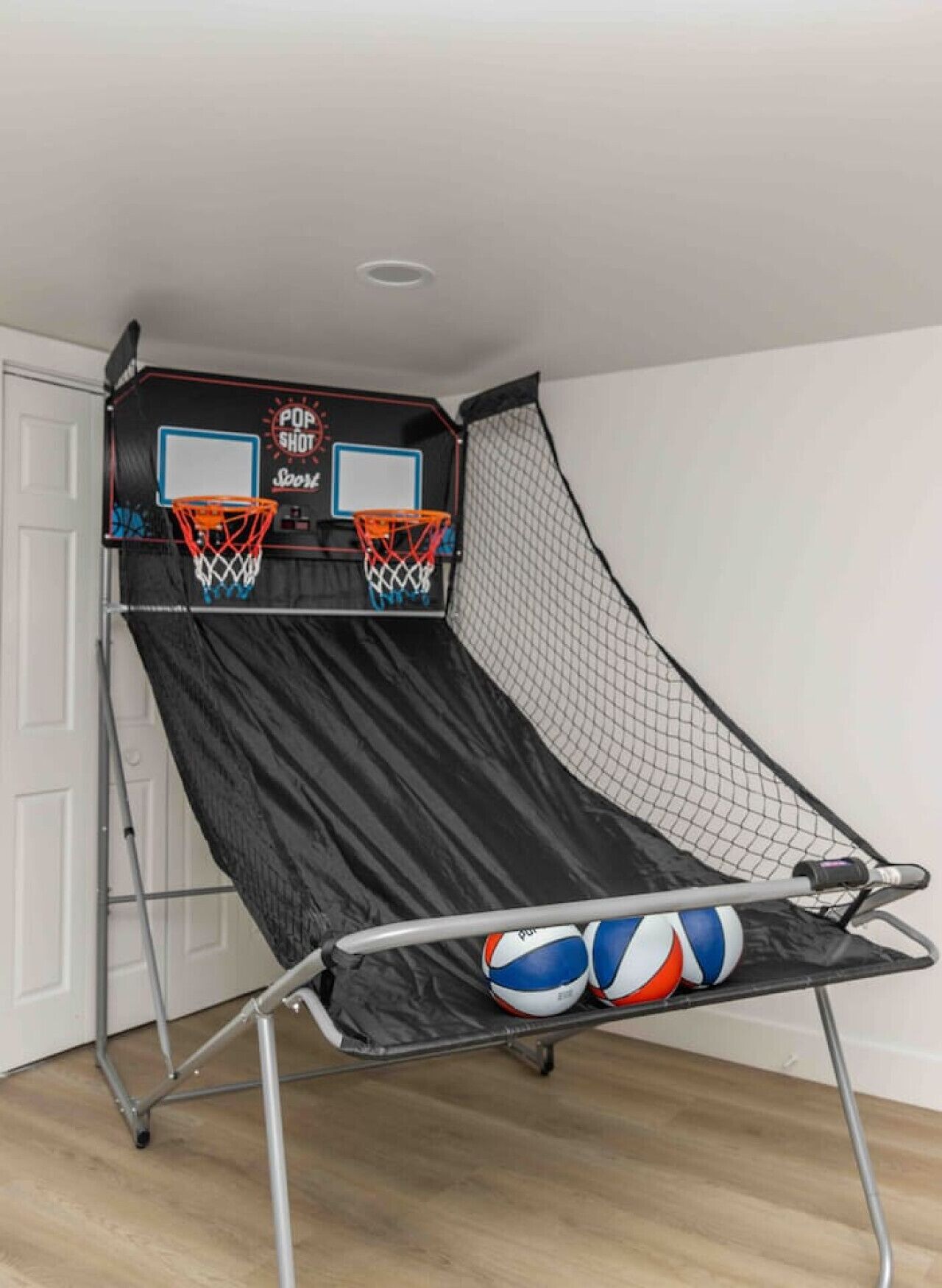 A portable basketball court with two hoops and a net.