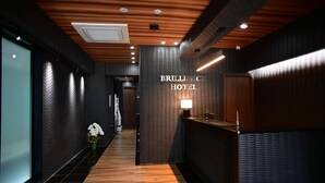 Eine moderne Hotelhalle mit einer Rezeption, einer Wandtafel und Holzboden.