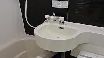 Un baño pequeño con bañera, lavamanos e inodoro.