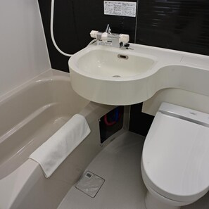 A compact bathroom with a bathtub, a sink, and a toilet. - BRILLIANCE HOTEL (Nagoya)