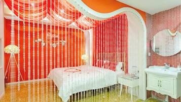 Una habitación con una cama, una tocador con espejo y una pared con diseño decorativo.