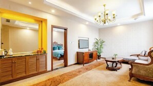 A hotel room with a large mirror, a bed, a TV, a sofa, a coffee table, and a carpeted floor. - Hawaii Hotel (Leshan Jiaxing Road Food Street) (Leshan)