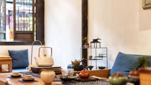 Un servicio de té tradicional con tetera, tazas y bandeja sobre una mesa de madera.