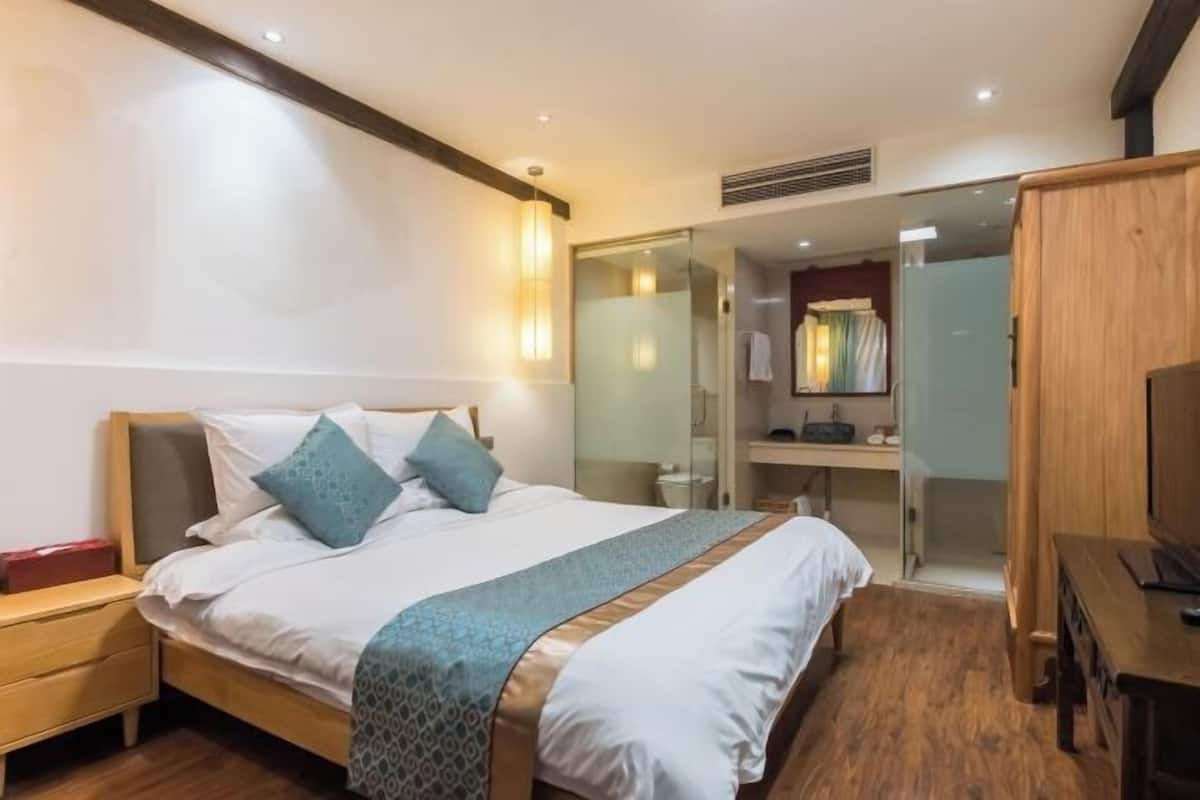 Ein Schlafzimmer mit Bett, Nachttisch, Kleiderschrank und Spiegel.