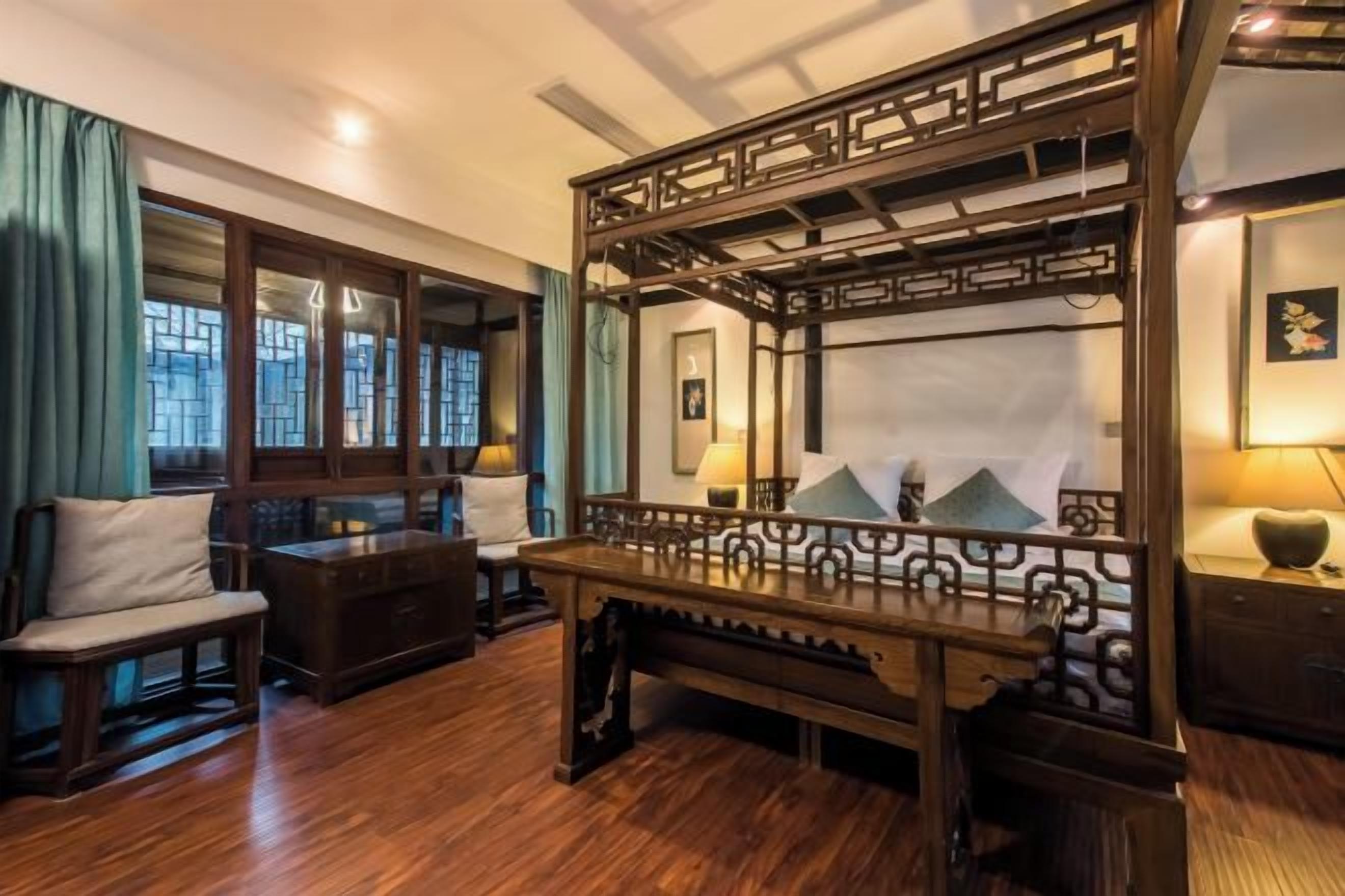 A traditional room with a wooden bench, a mirror, and a view of the outside through a window.