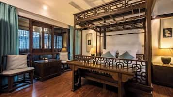 A traditional room with a wooden bench, a mirror, and a view of the outside through a window.