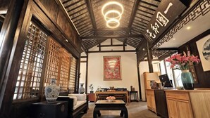 Un interior tradicional con techo de madera, un mostrador de recepción y un sofá.